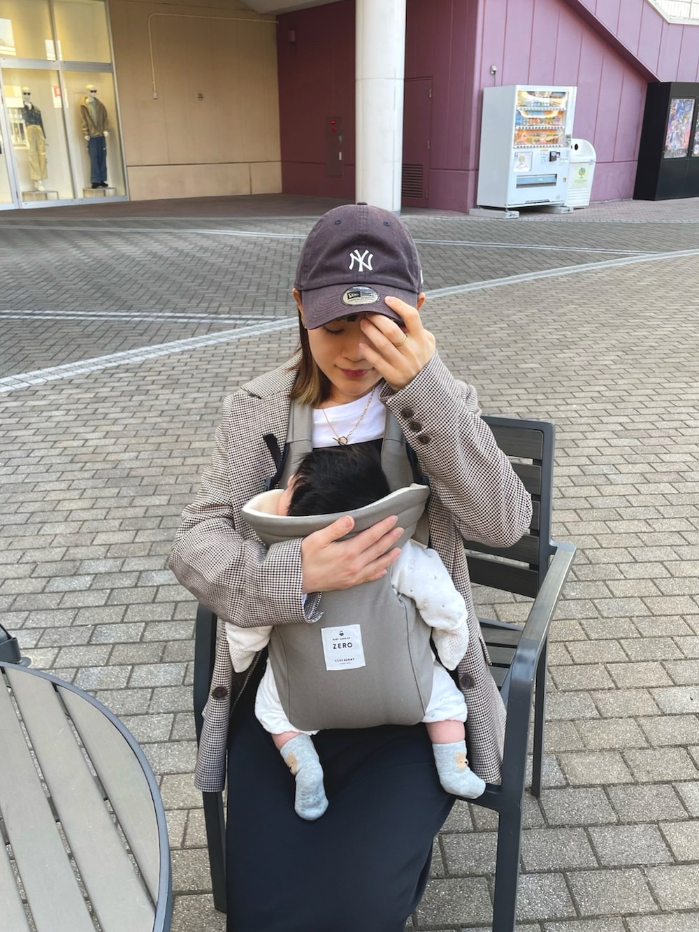 ブラウン系のテーラードジャケット、ブラック系のワンピース、ホワイト系のスニーカーを着用したレディースの冬コーディネートの3枚目の写真