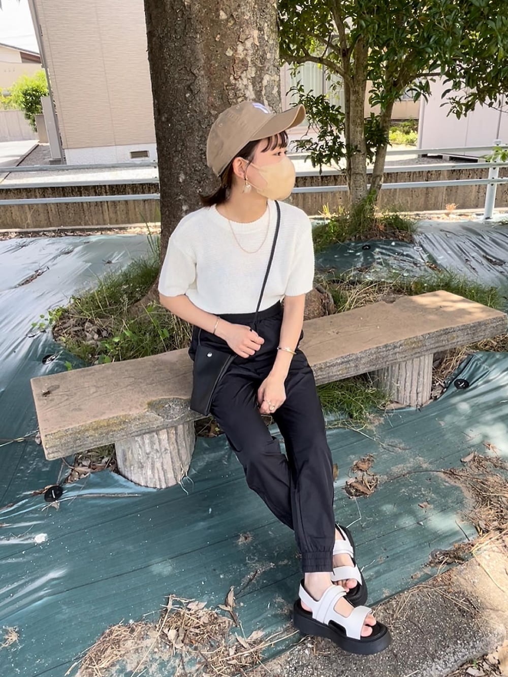 ホワイト系のニット/セーター、ブラック系のその他パンツ、ブラック系のショルダーバッグを着用したレディースの夏コーディネートの5枚目の写真