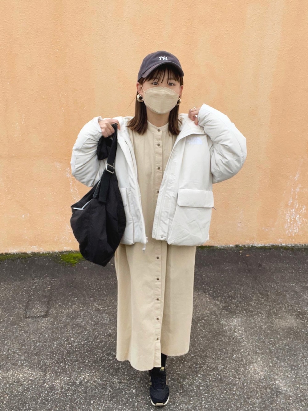 ホワイト系のワンピース、ホワイト系のジャケット/アウター、ブラック系のショルダーバッグを着用したレディースの冬コーディネートの2枚目の写真