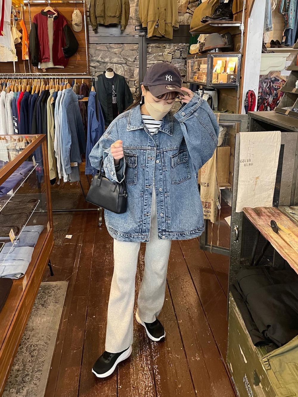 ブルー系のデニムジャケット、グレー系のその他パンツ、ブラック系のスニーカーを着用したレディースの春コーディネートの4枚目の写真