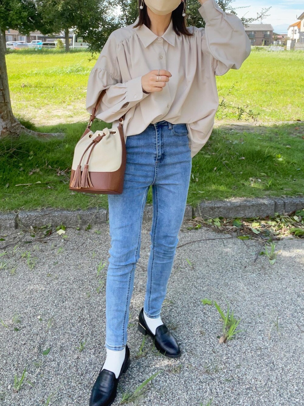 ベージュ系のシャツ/ブラウス、ブルー系のデニムパンツ、ブラック系のローファーを着用したレディースの秋コーディネートの3枚目の写真