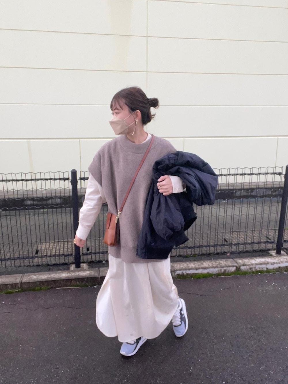 ホワイト系のシャツワンピース、ブラウン系のベスト、ブラック系のMA-1を着用したレディースの秋コーディネートの5枚目の写真