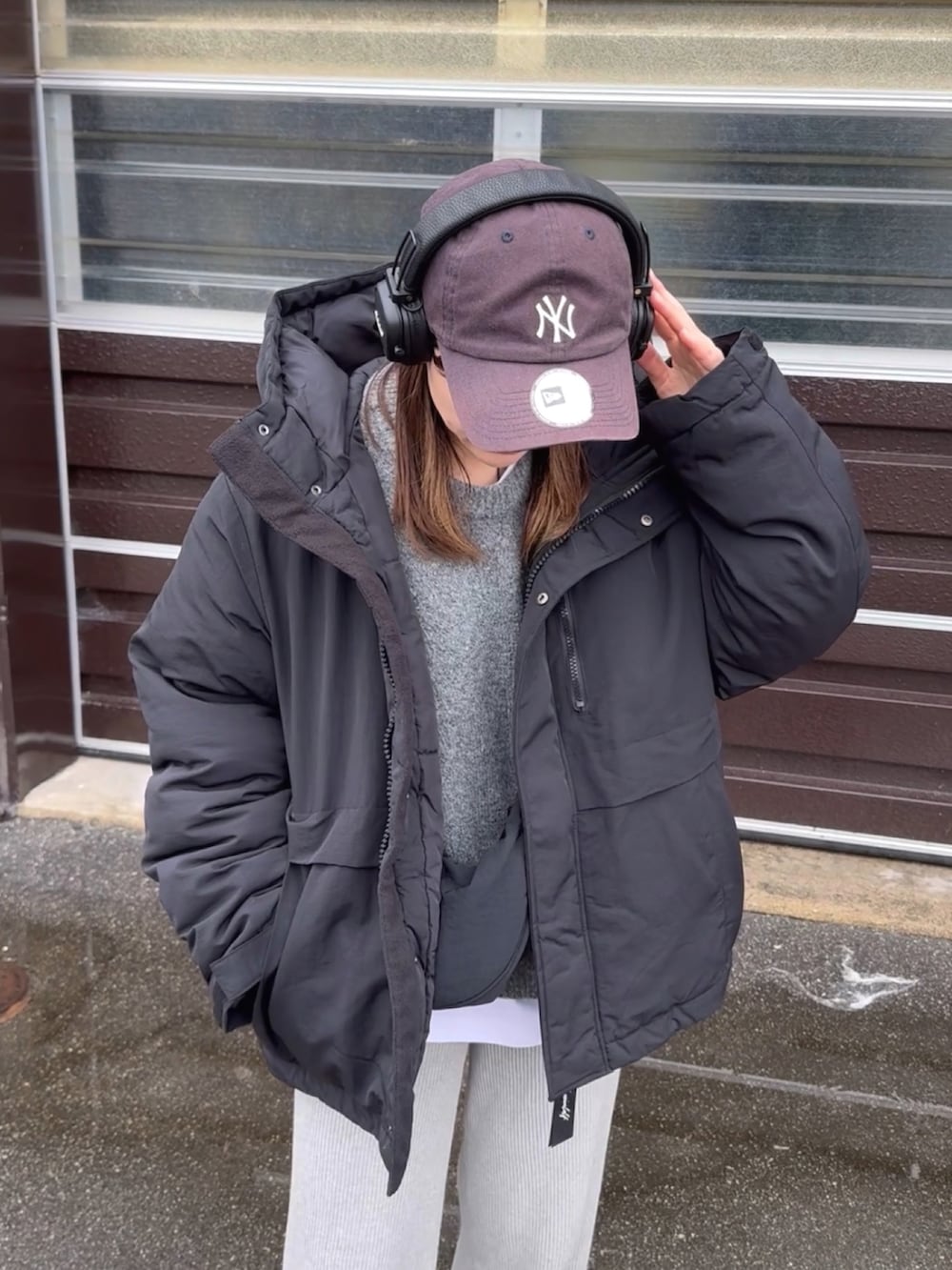 ブラック系のダウンジャケット/コート、グレー系のニット/セーター、グレー系のパンツを着用したレディースの冬コーディネートの2枚目の写真