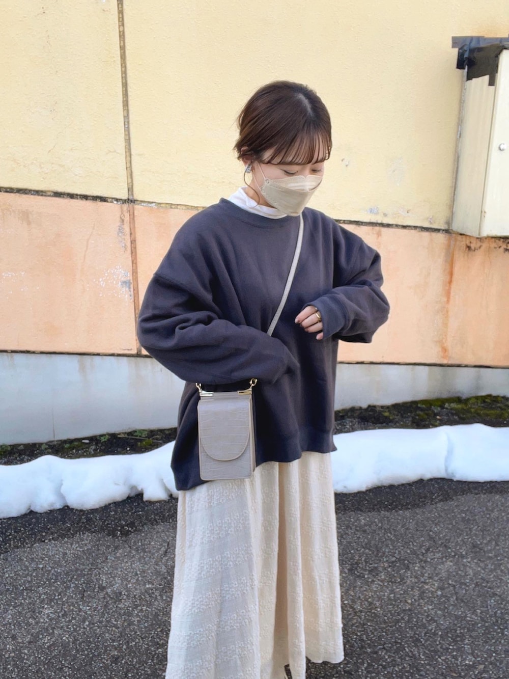グレー系のスウェット、ホワイト系のTシャツ/カットソー、ベージュ系のスカートを着用したレディースの冬コーディネートの3枚目の写真