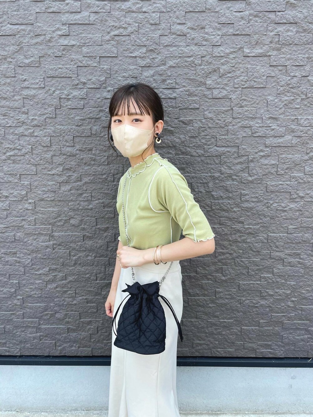 グリーン系のTシャツ/カットソー、ホワイト系のスカート、ブラック系のショルダーバッグを着用したレディースの夏コーディネートの3枚目の写真