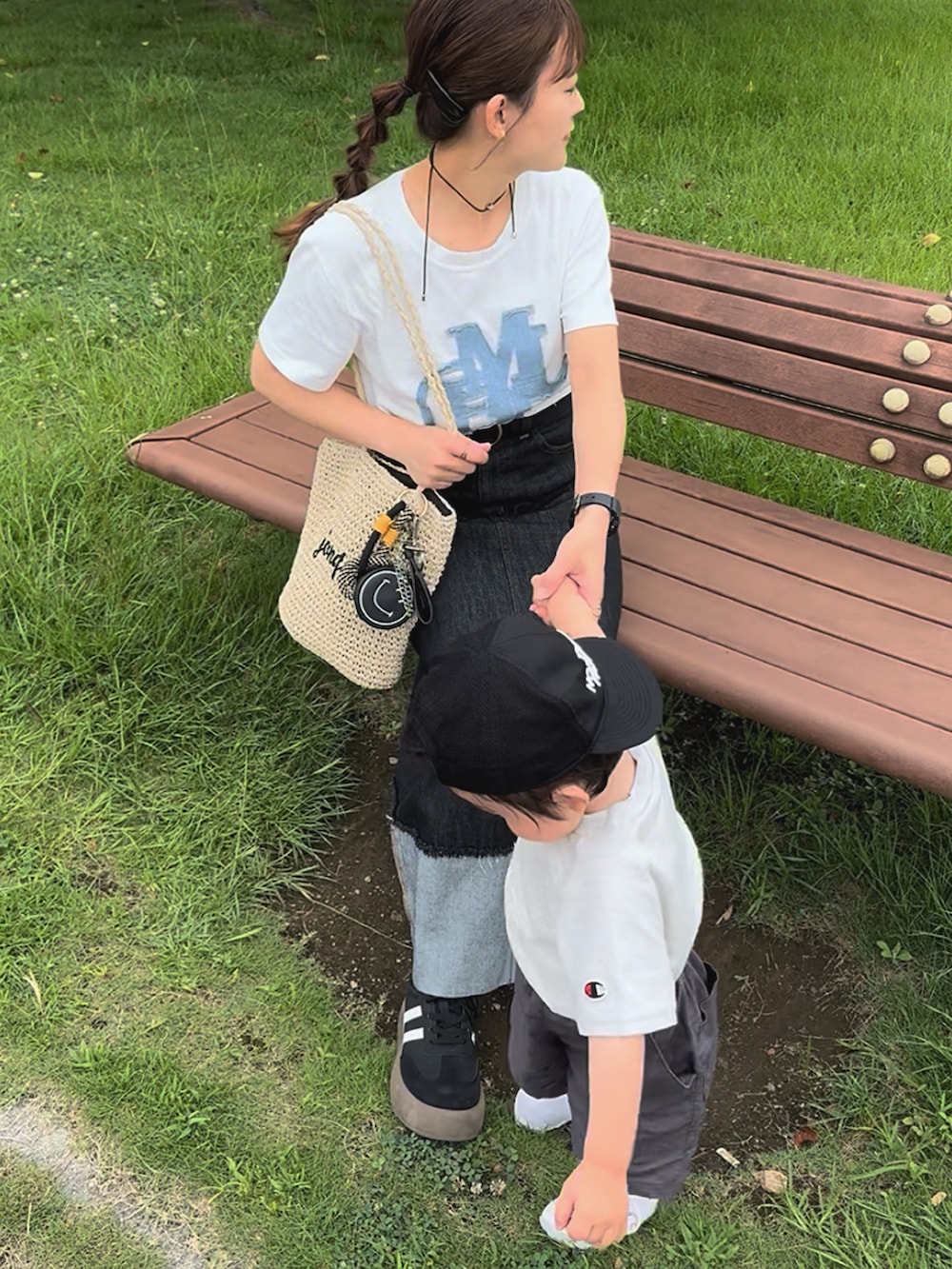 ホワイト系のTシャツ/カットソー、ブラック系のデニムスカート、ベージュ系のかごバッグを着用したレディースの夏コーディネートの4枚目の写真