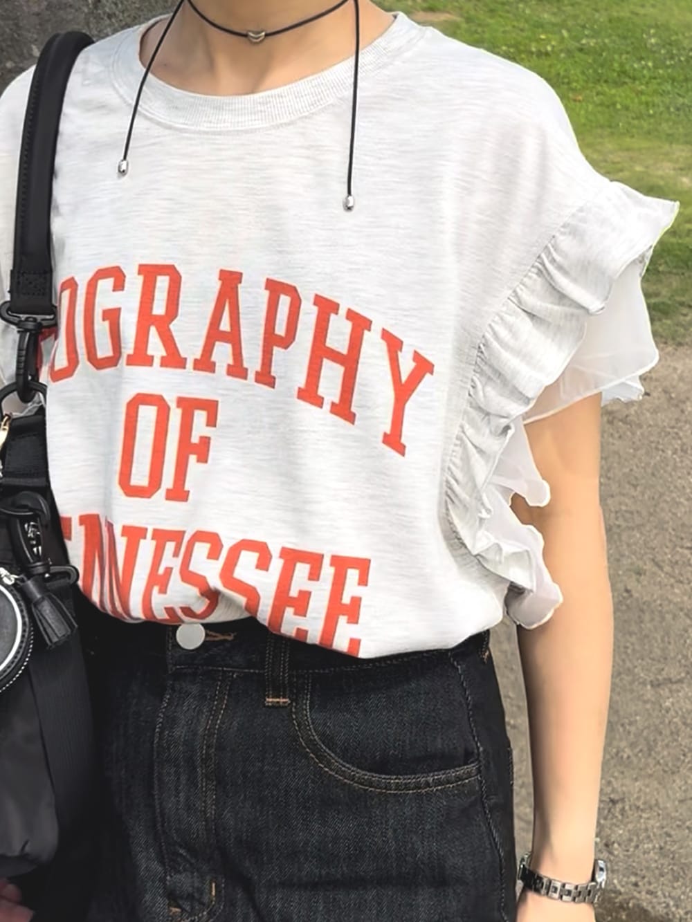 ベージュ系のTシャツ/カットソー、ブラック系のデニムスカート、ブラック系のバッグを着用したレディースの夏コーディネートの5枚目の写真