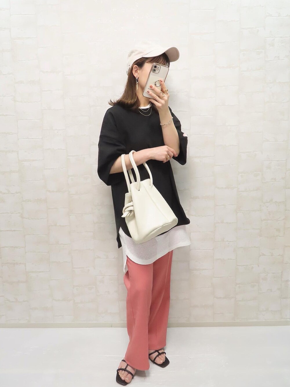 ブラック系のTシャツ/カットソー、ホワイト系のタンクトップ、ピンク系のスラックスを着用したレディースの春コーディネートの2枚目の写真