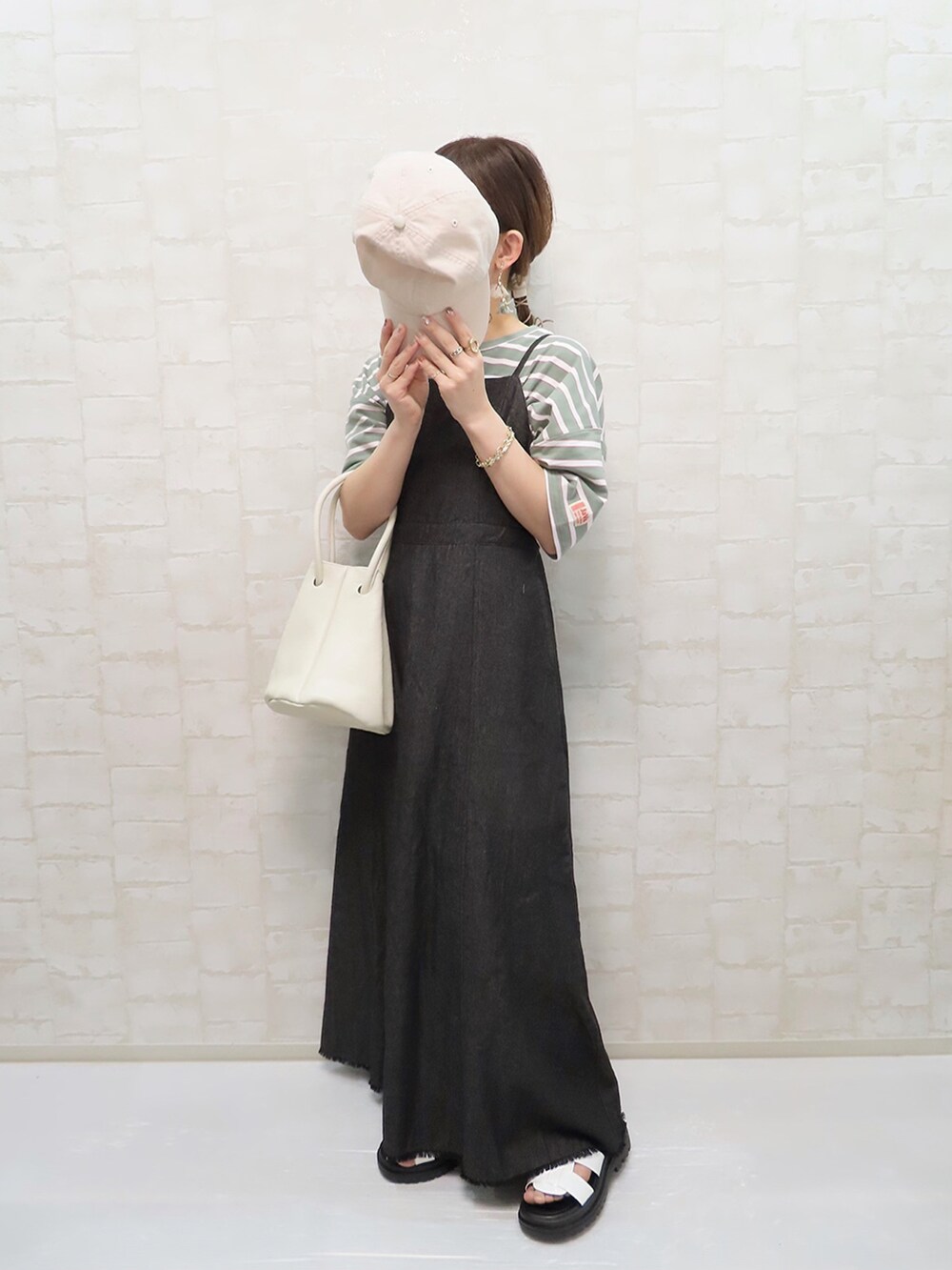 グリーン系のTシャツ/カットソー、ブラック系のワンピース、ホワイト系のハンドバッグを着用したレディースの春コーディネートの4枚目の写真