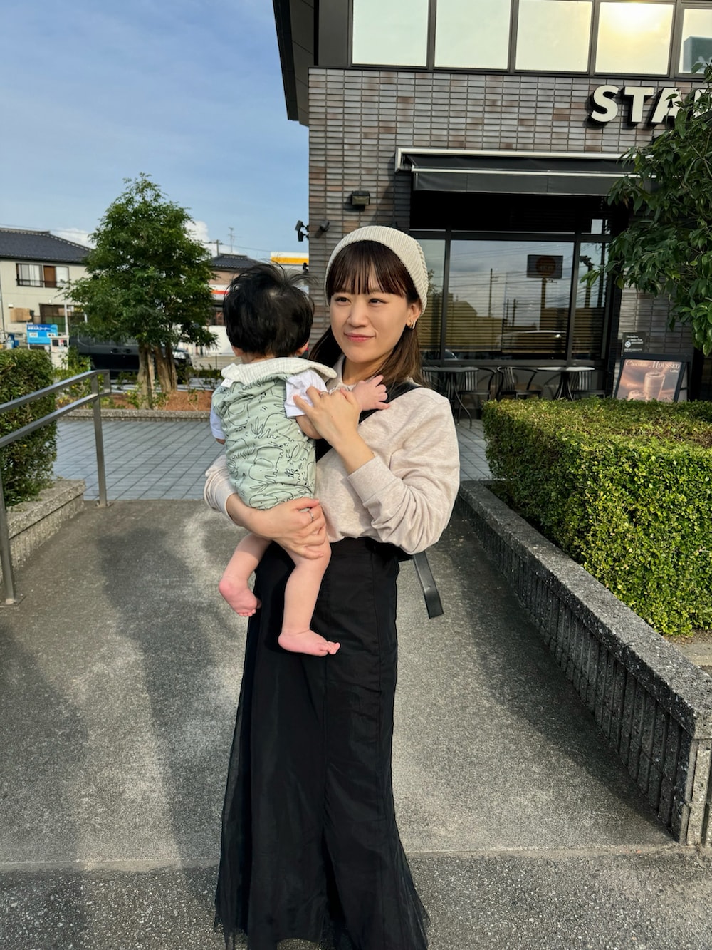 ベージュ系のポロシャツ、ブラック系のスカート、ブラック系のショルダーバッグを着用したレディースの秋コーディネートの2枚目の写真