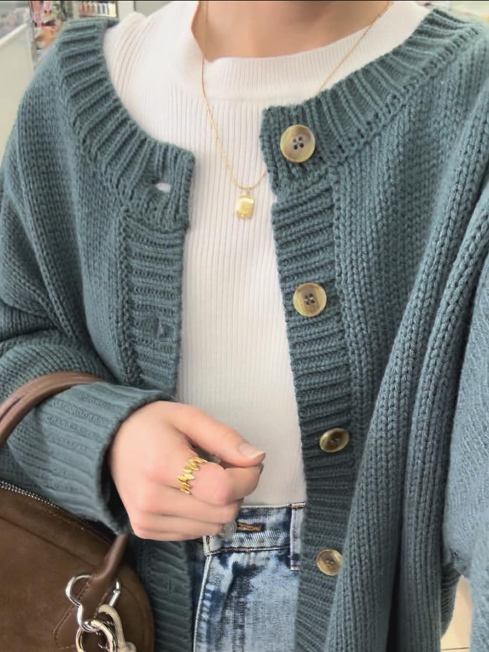 グリーン系のカーディガン/ボレロ、その他のデニムパンツ、ブラウン系のバッグを着用したレディースの春コーディネートの4枚目の写真