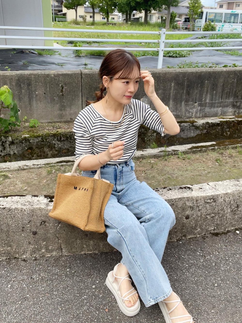 ブルー系のTシャツ/カットソー、その他のデニムパンツ、ベージュ系のショルダーバッグを着用したレディースの夏コーディネートの4枚目の写真