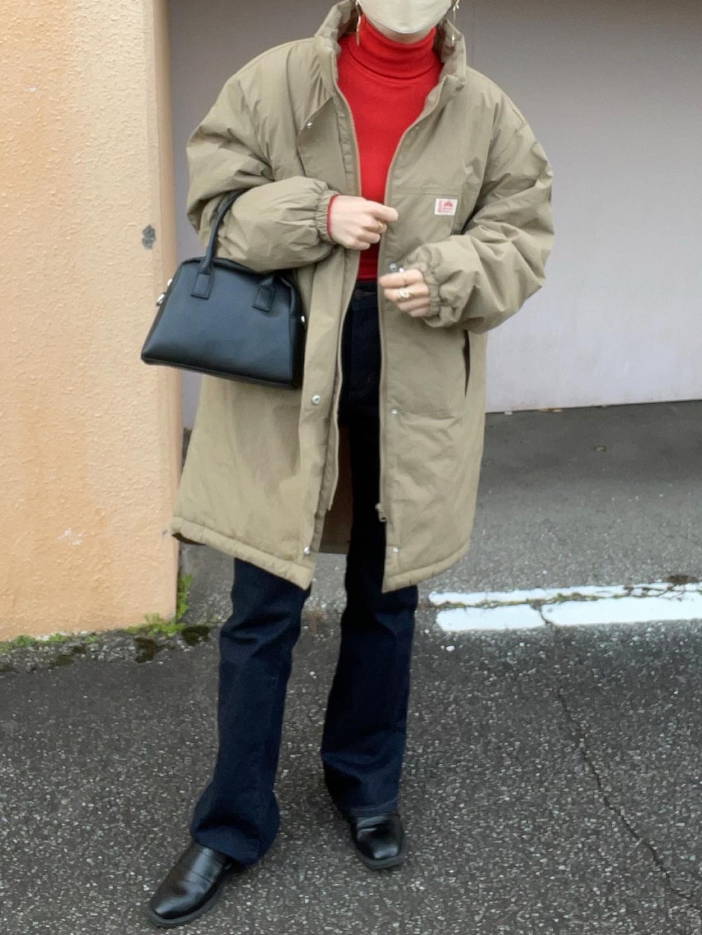 ベージュ系のダウンジャケット/コート、レッド系のトップス、ブルー系のデニムパンツを着用したレディースの冬コーディネートの4枚目の写真