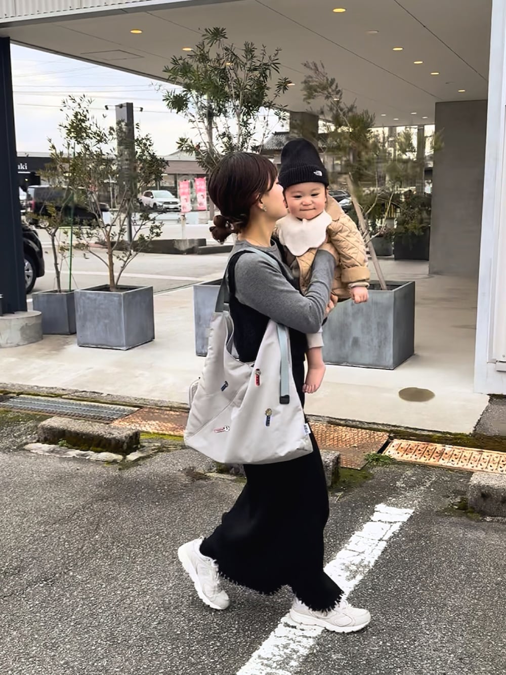 グレー系のTシャツ/カットソー、ブラック系のベスト、ブラック系のスカートを着用したレディースの春コーディネートの2枚目の写真