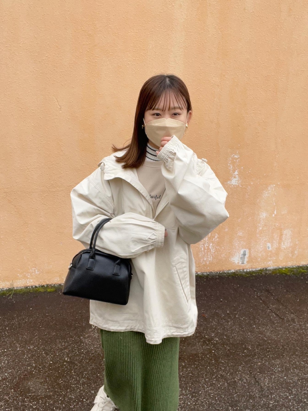 ベージュ系のスウェット、グリーン系のスカート、ホワイト系のニット/セーターを着用したレディースの冬コーディネートの2枚目の写真