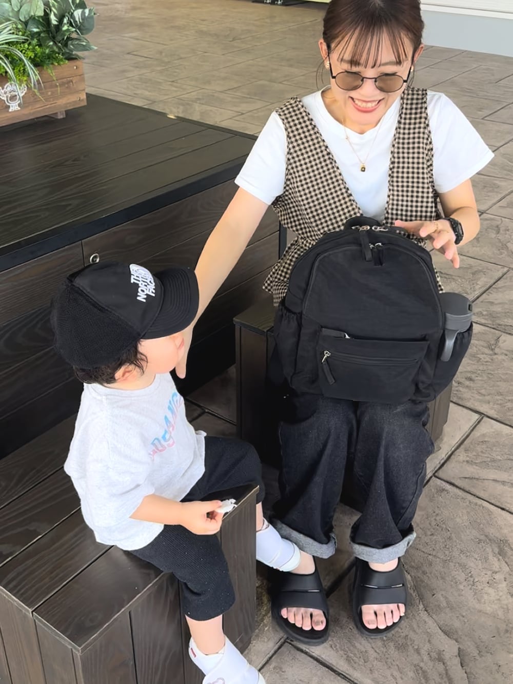 ブラック系のサンダル、ブラウン系のベスト、ブルー系のデニムパンツを着用したレディースの夏コーディネートの2枚目の写真