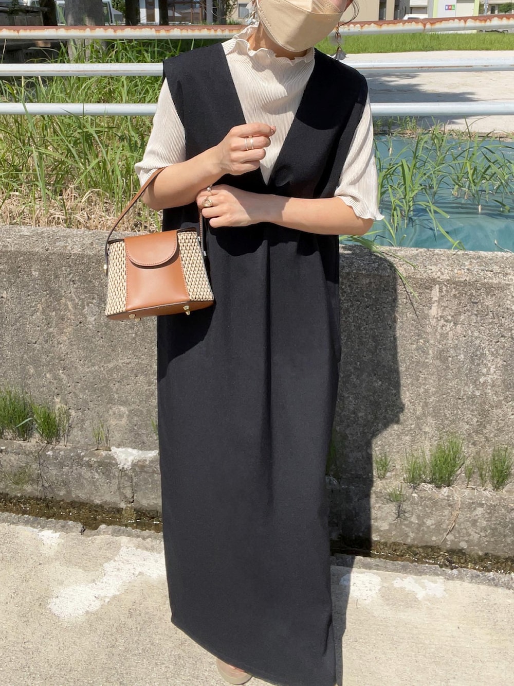 ブラック系のジャンパースカート、ホワイト系のTシャツ/カットソー、イエロー系のショルダーバッグを着用したレディースの夏コーディネートの3枚目の写真