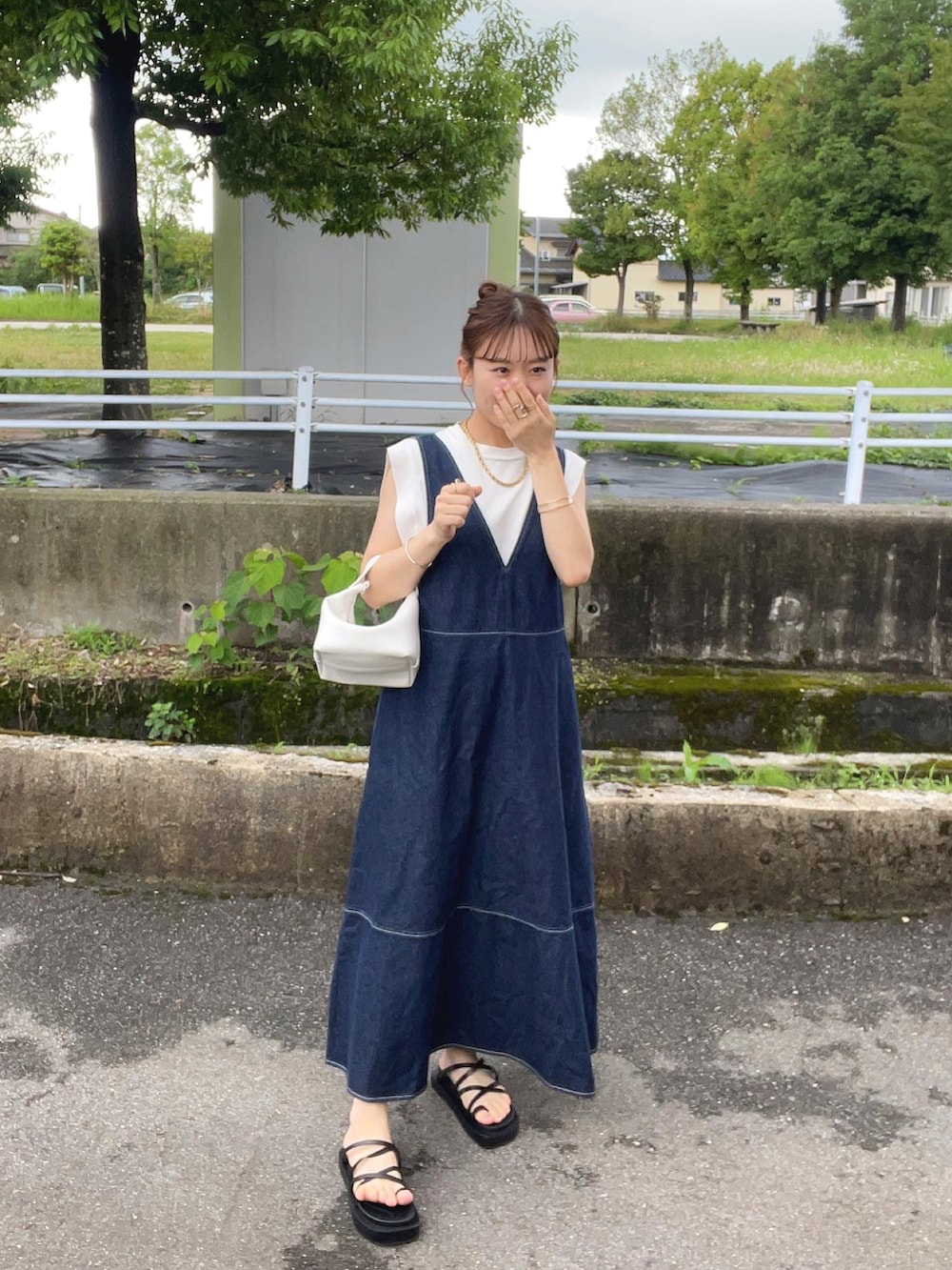 ブルー系のワンピース/ドレス、ホワイト系のハンドバッグ、ブラック系のサンダルを着用したレディースの夏コーディネートの2枚目の写真
