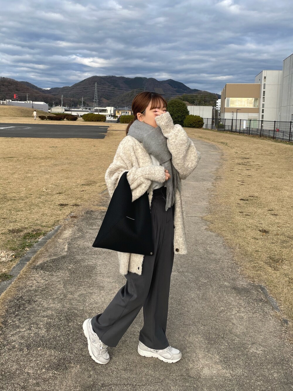 ベージュ系のカーディガン/ボレロ、グレー系のその他パンツ、ブラック系のトートバッグを着用したレディースの冬コーディネートの3枚目の写真