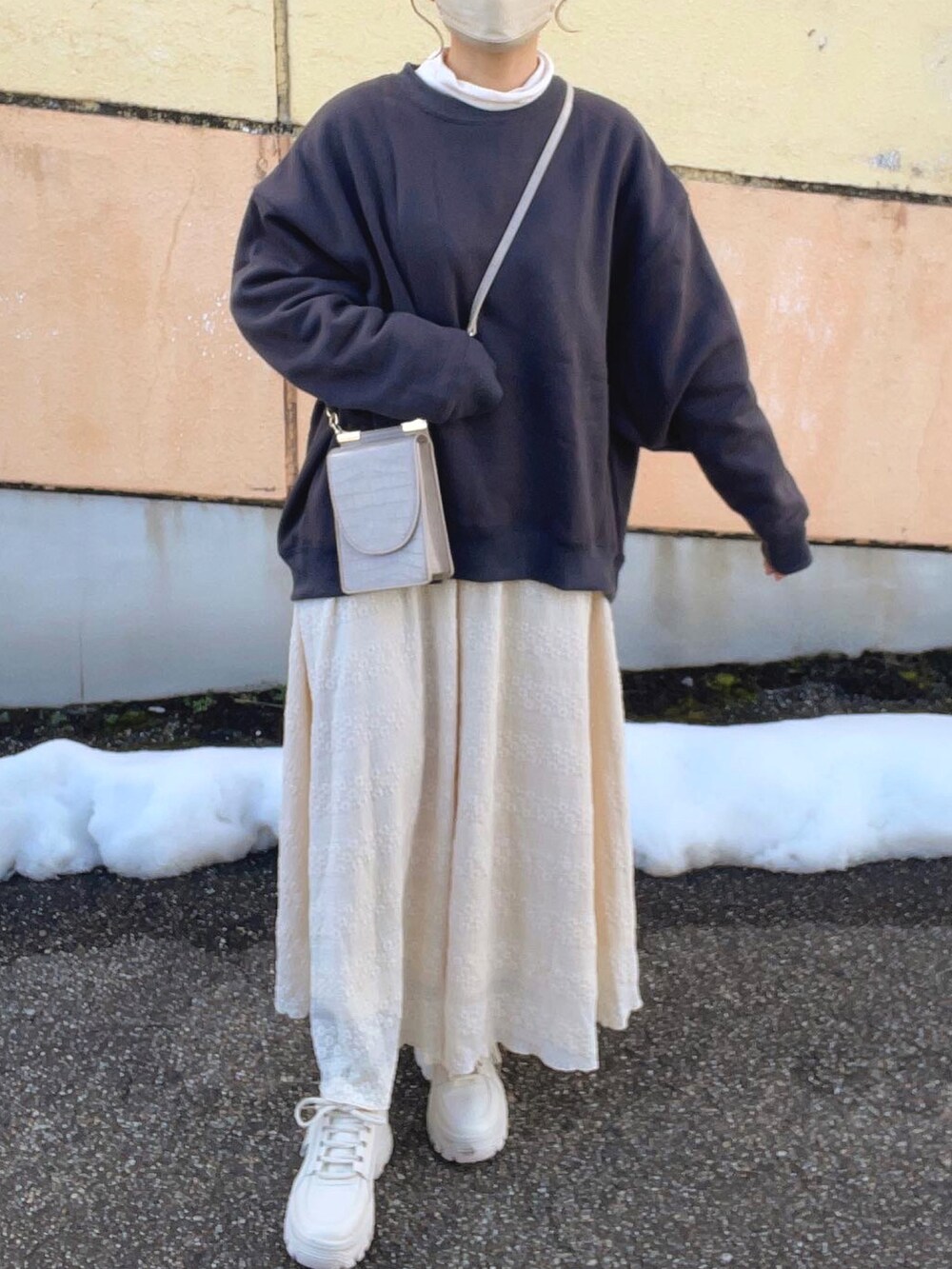 グレー系のスウェット、ホワイト系のTシャツ/カットソー、ベージュ系のスカートを着用したレディースの冬コーディネートの5枚目の写真