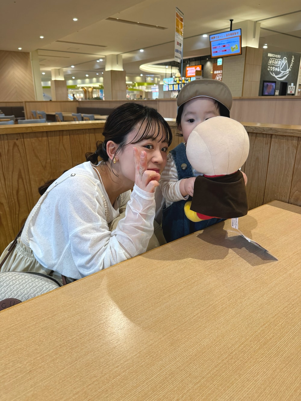 ベージュ系のワンピース、ブルー系のデニムジャケット、ホワイト系のショルダーバッグを着用したレディースの春コーディネートの5枚目の写真