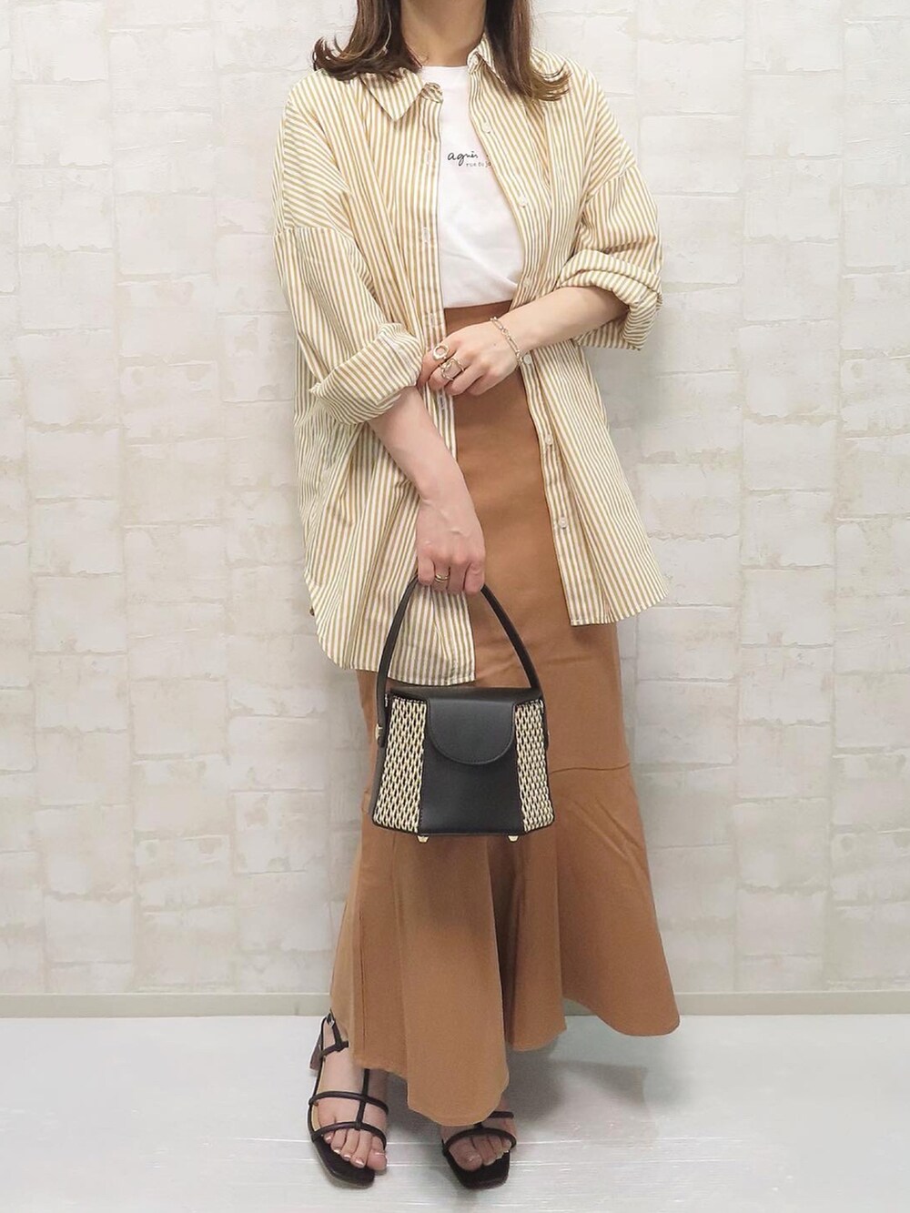 ブラック系のサンダル、イエロー系のシャツ/ブラウス、ホワイト系のTシャツ/カットソーを着用したレディースの春コーディネートの3枚目の写真