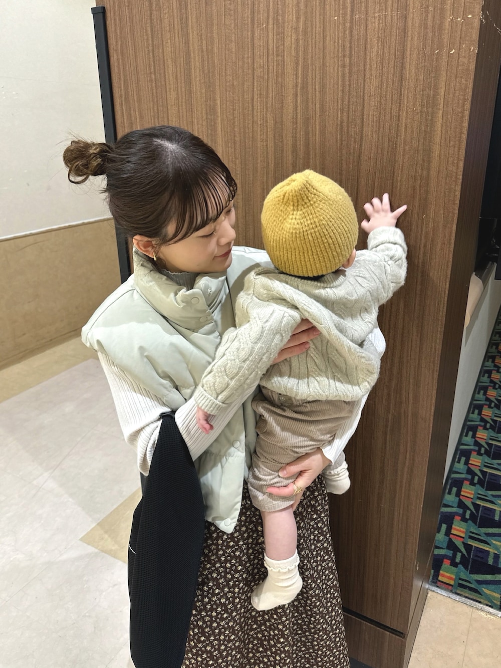 ブラウン系のワンピース/ドレス、ベージュ系のダウンベスト、ホワイト系のニット/セーターを着用したレディースの冬コーディネートの5枚目の写真