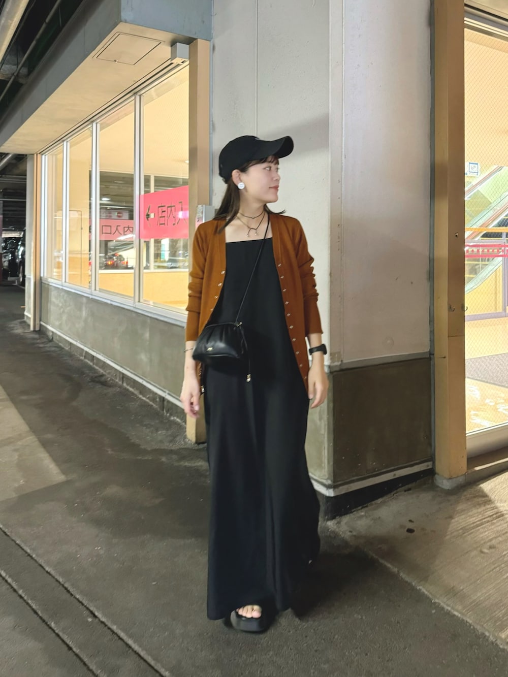 イエロー系のカーディガン/ボレロ、ブラック系のワンピース、ブラック系のショルダーバッグを着用したレディースの夏コーディネートの4枚目の写真