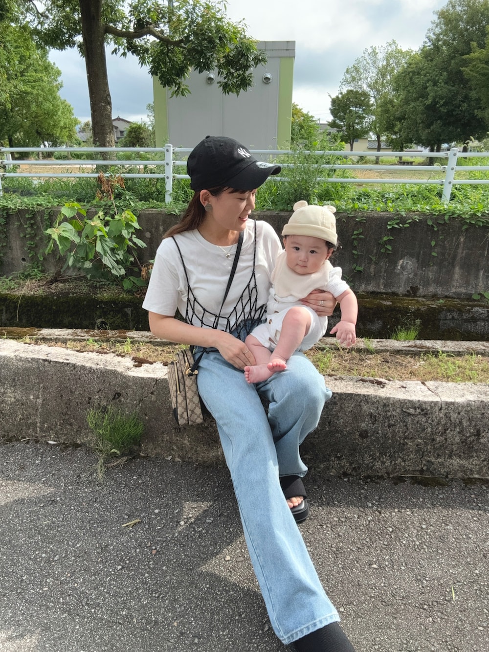 ブラック系のキャミソール、ブルー系のデニムパンツ、ブラック系のサンダルを着用したレディースの夏コーディネートの2枚目の写真