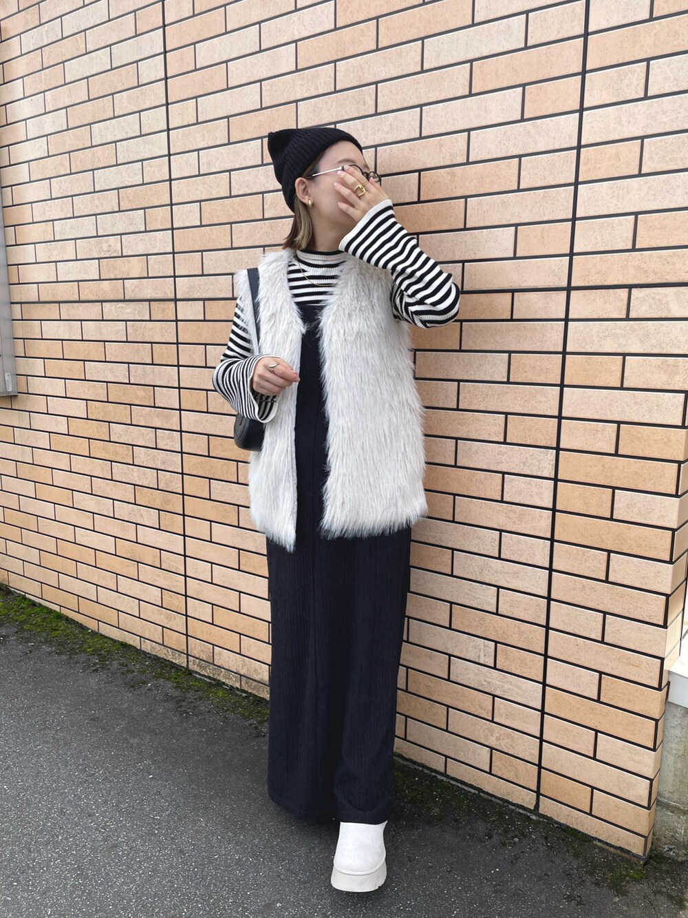 ホワイト系のベスト、ホワイト系のトップス、ブラック系のワンピース/ドレスを着用したレディースの秋コーディネートの2枚目の写真