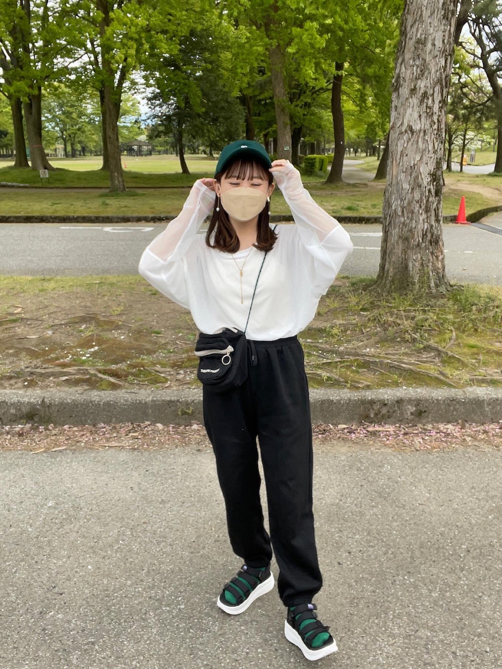 ホワイト系のTシャツ/カットソー、ブラック系のスウェットパンツ、ブラック系のショルダーバッグを着用したレディースの春コーディネートの5枚目の写真