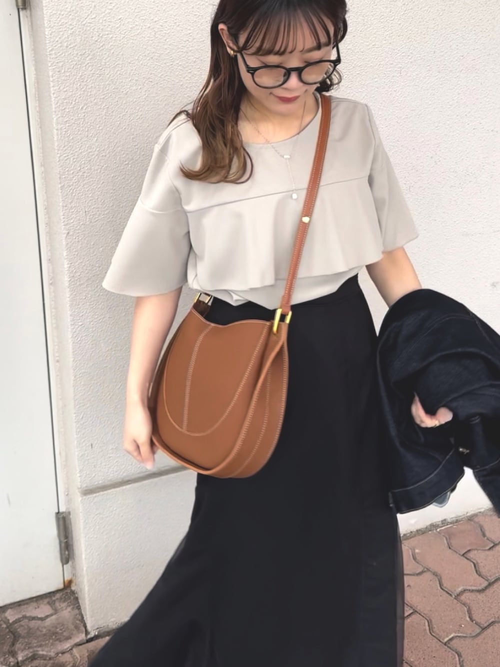 ブラック系のスカート、グレー系のシャツ/ブラウス、ブラウン系のショルダーバッグを着用したレディースの春コーディネートの2枚目の写真