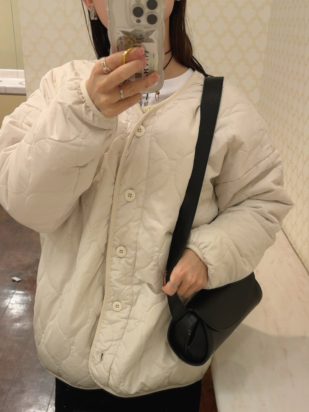 ホワイト系のノーカラージャケット、ブラック系のスカート、ベージュ系のストール/ショールを着用したレディースの冬コーディネートの5枚目の写真