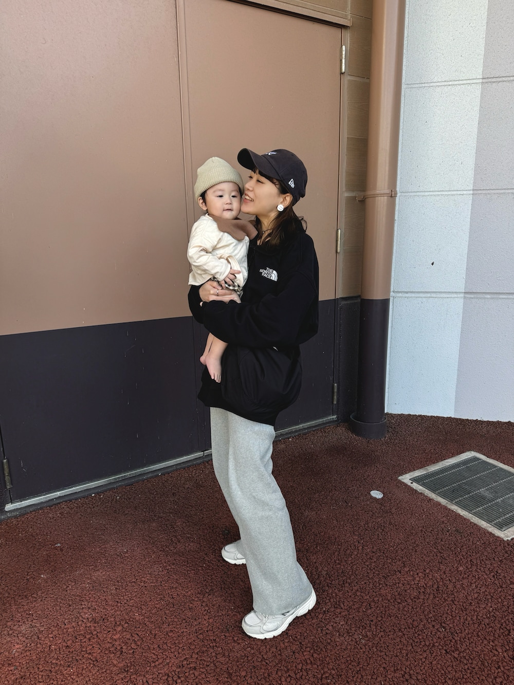 ブラック系のスウェット、グレー系のパンツ、ブラック系のショルダーバッグを着用したレディースの秋コーディネートの2枚目の写真