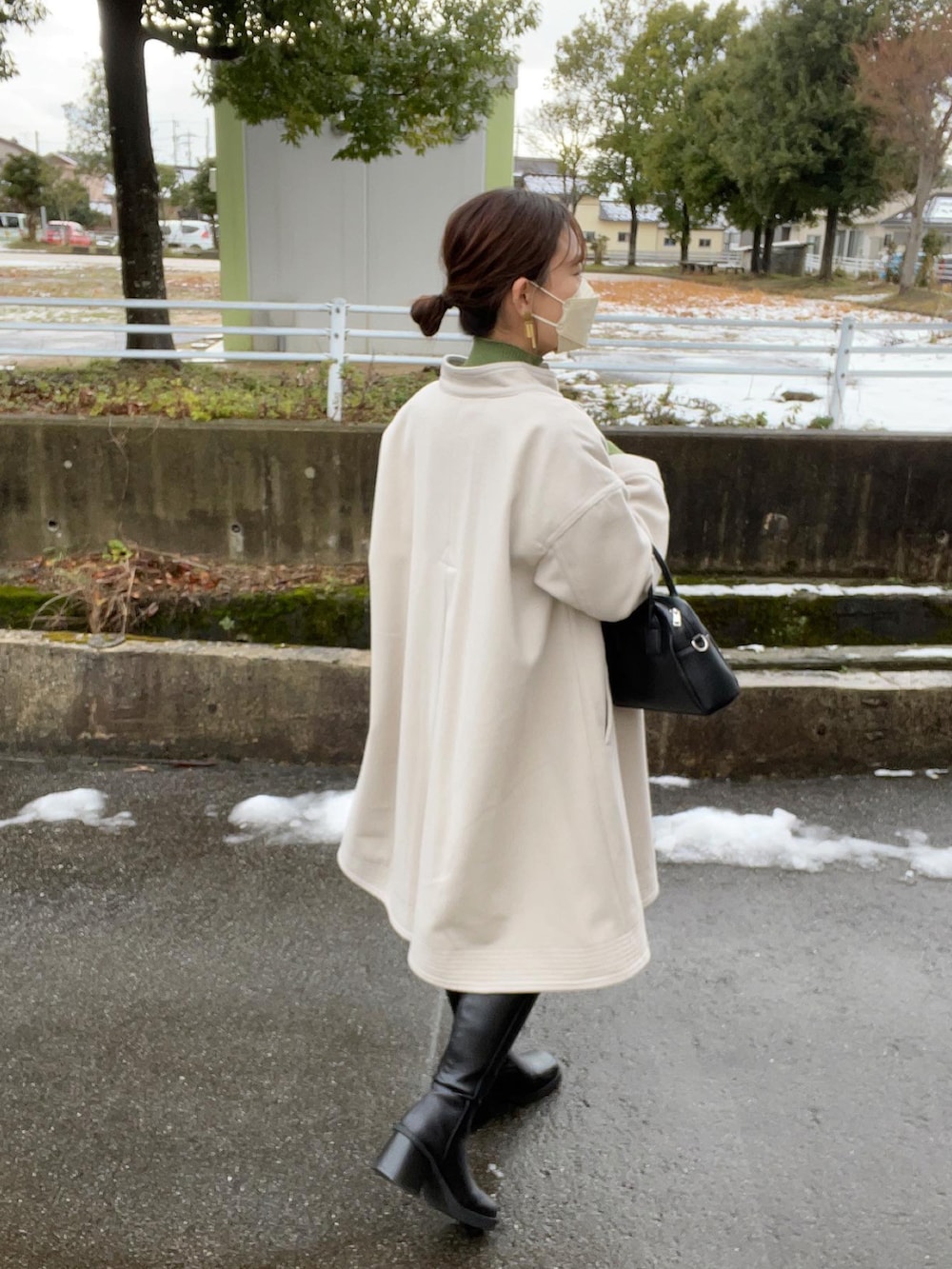 ホワイト系のその他アウター、グリーン系のニット/セーター、ブラック系のボストンバッグを着用したレディースの冬コーディネートの4枚目の写真