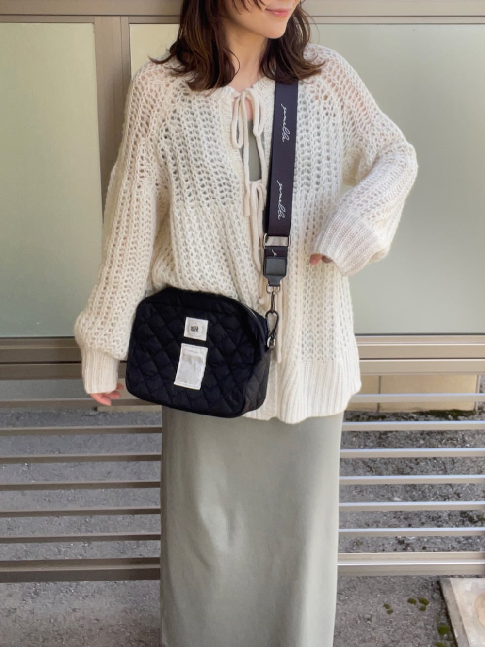 ホワイト系のカーディガン/ボレロ、ブラック系のショルダーバッグ、グリーン系のワンピース/ドレスを着用したレディースの春コーディネートの3枚目の写真