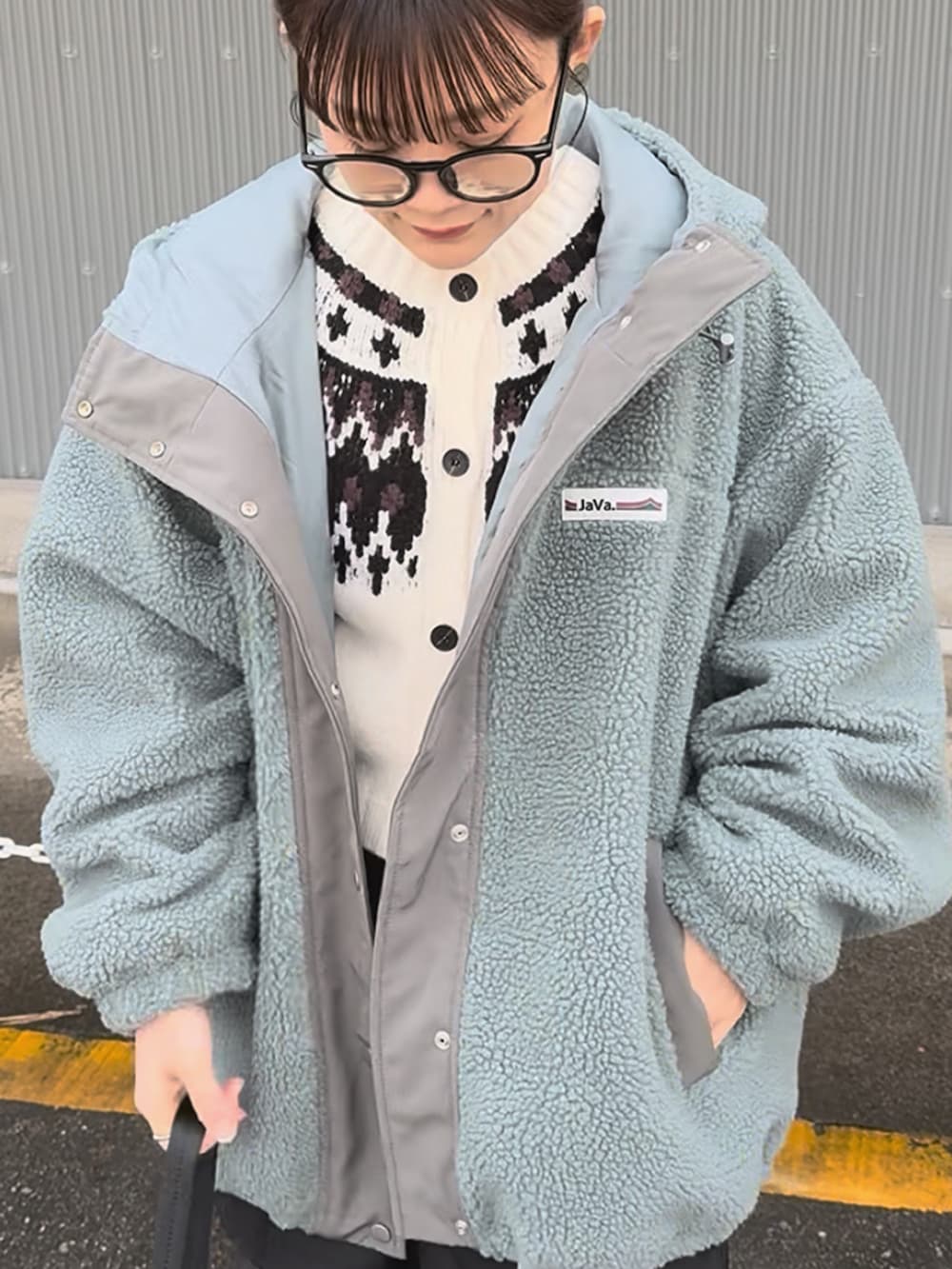 ブルー系のブルゾン、ブラック系のスラックス、ホワイト系のカーディガン/ボレロを着用したレディースの冬コーディネートの5枚目の写真