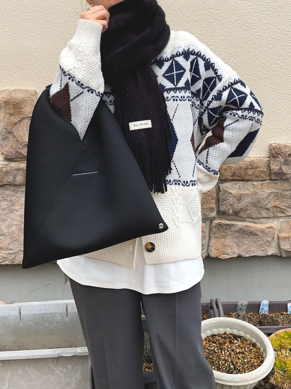 ベージュ系のニット/セーター、グレー系のその他パンツ、ブラック系のマフラーを着用したレディースの冬コーディネートの3枚目の写真