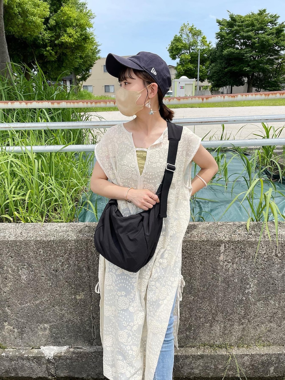 ホワイト系のワンピース、ブラック系のショルダーバッグ、ブラック系のサンダルを着用したレディースの夏コーディネートの3枚目の写真