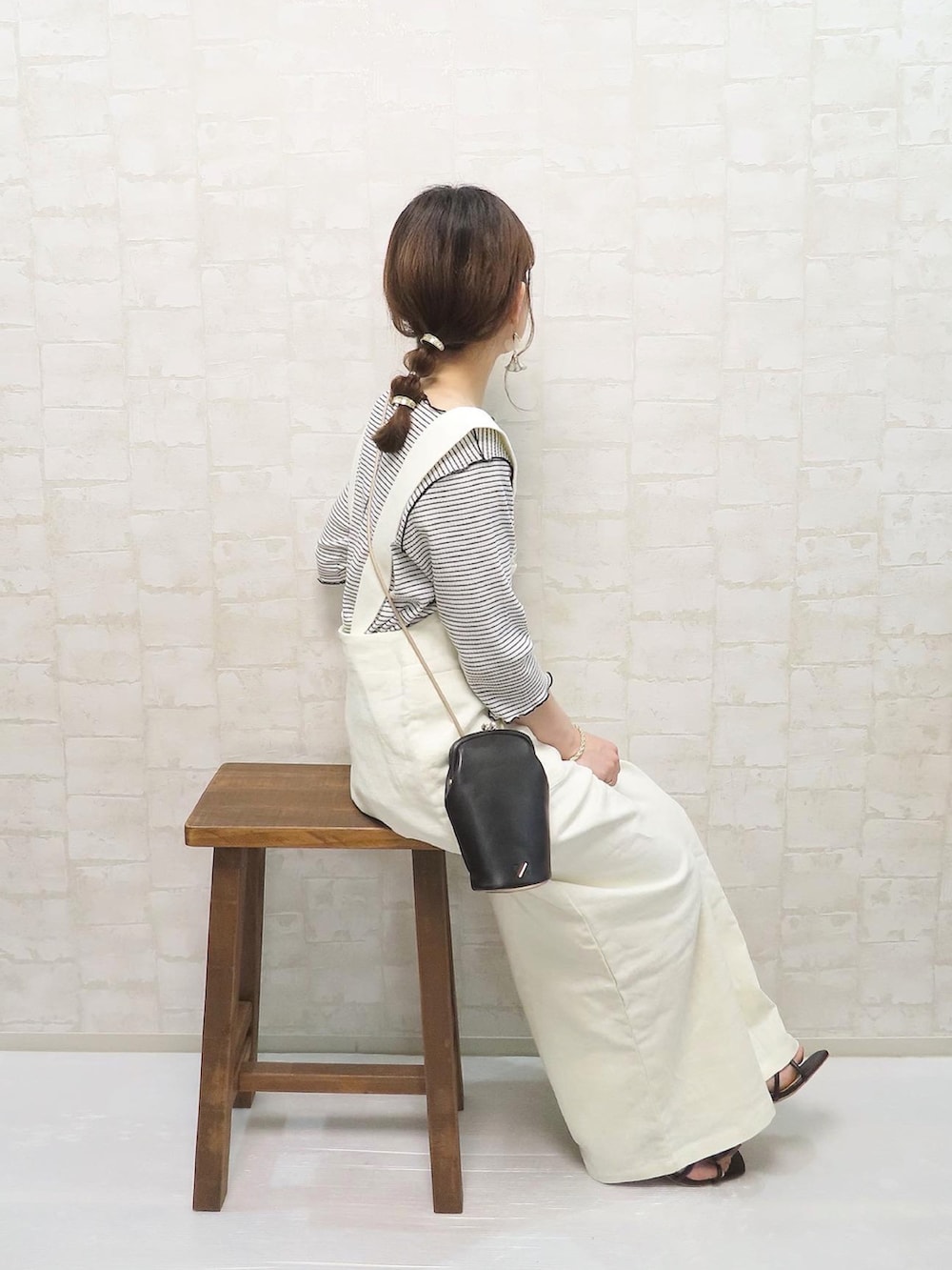 ホワイト系のサロペット/オーバーオール、ホワイト系のTシャツ/カットソー、ブラック系のショルダーバッグを着用したレディースの春コーディネートの2枚目の写真