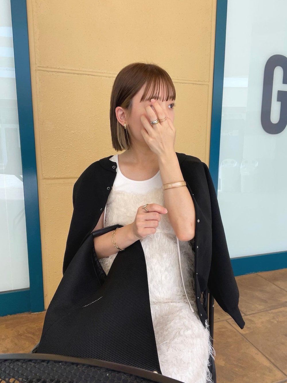 ブラック系のカーディガン/ボレロ、ホワイト系のワンピース、ブラック系のトートバッグを着用したレディースの秋コーディネートの5枚目の写真