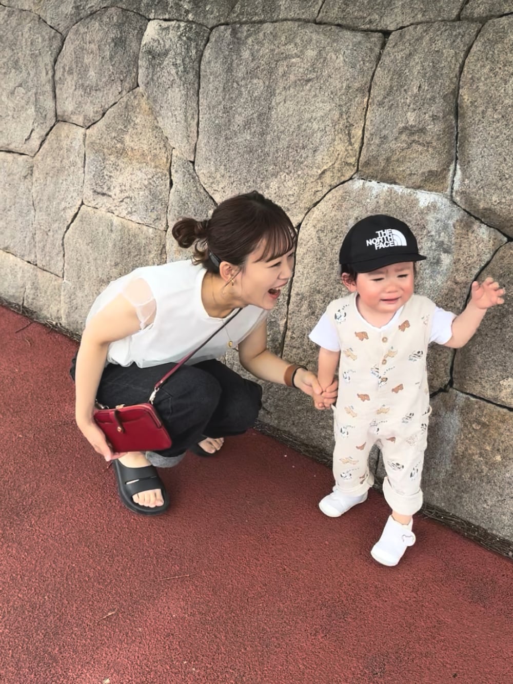 ブラック系のサンダル、レッド系のショルダーバッグ、ホワイト系のトップスを着用したレディースの夏コーディネートの3枚目の写真