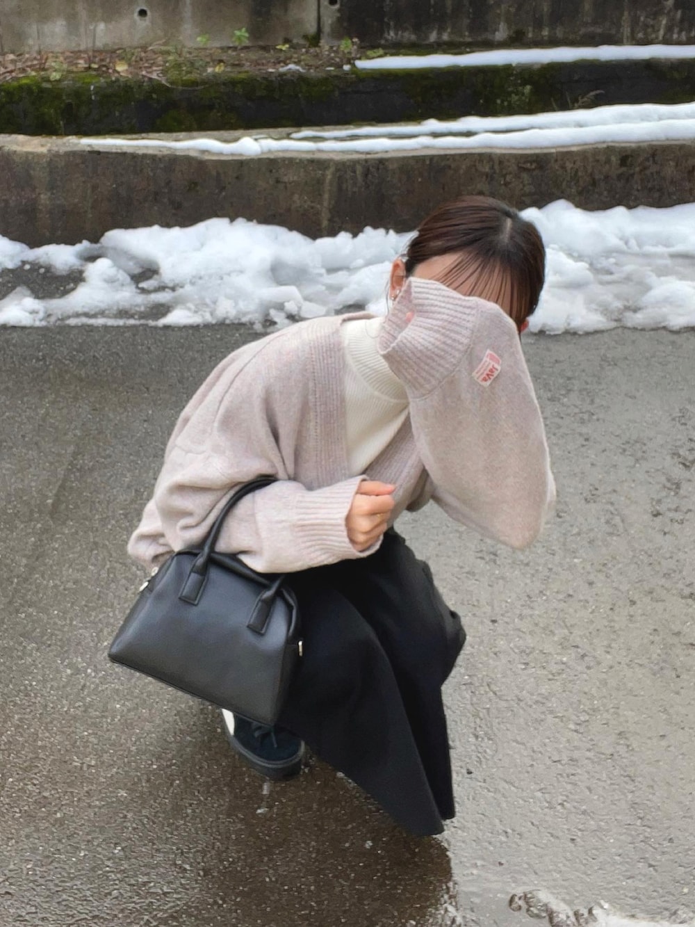 ピンク系のニット/セーター、ホワイト系のニット/セーター、ブラック系のスカートを着用したレディースの冬コーディネートの3枚目の写真