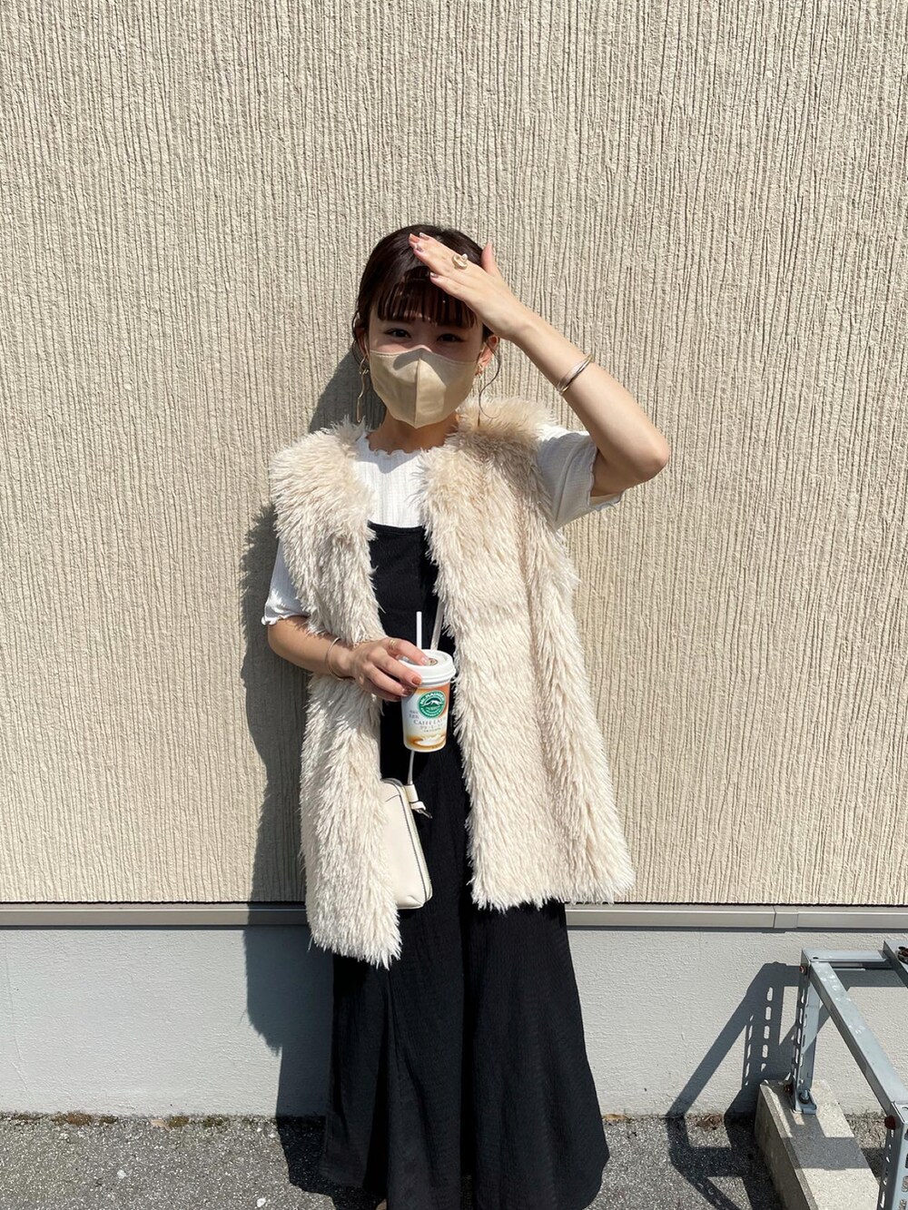 ホワイト系のベスト、ホワイト系のTシャツ/カットソー、ブラック系のワンピースを着用したレディースの夏コーディネートの4枚目の写真