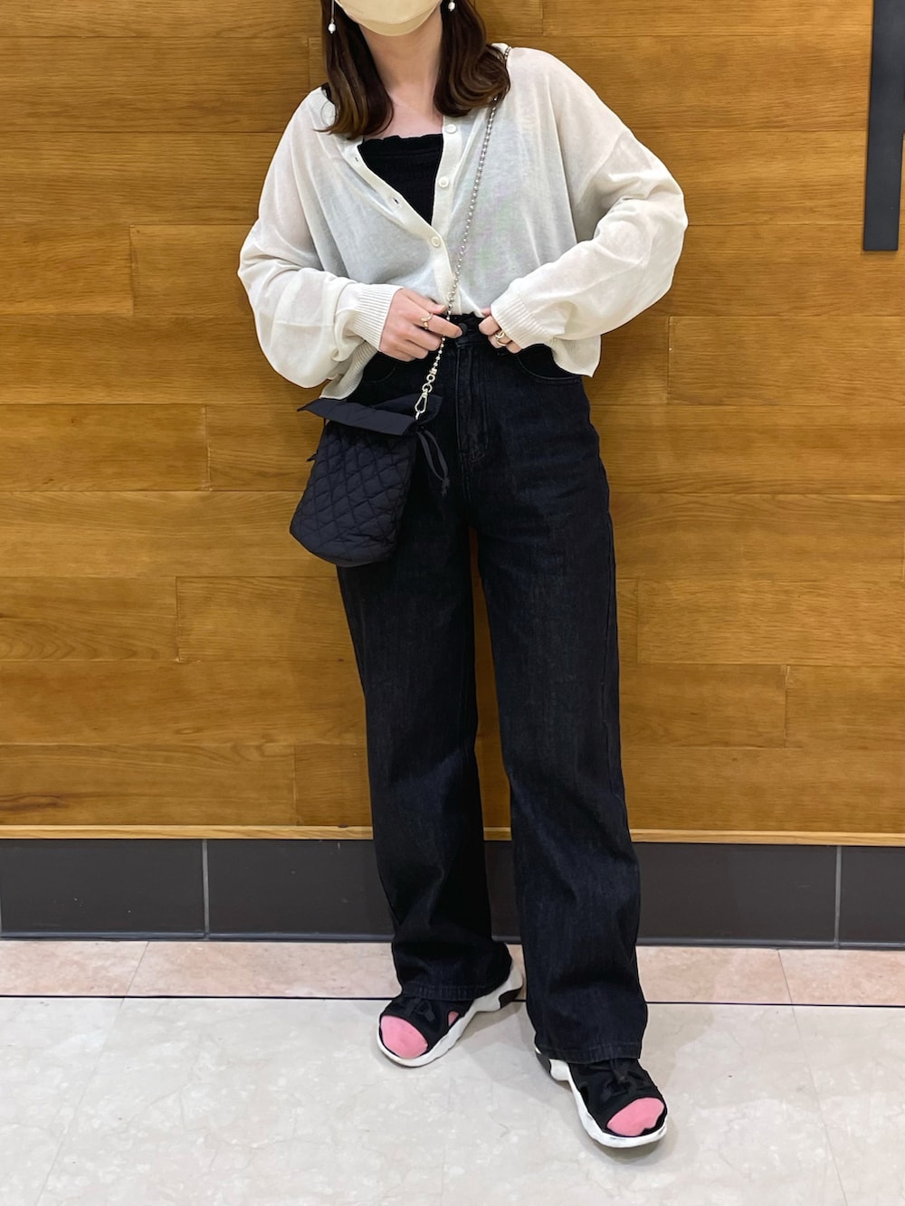 ホワイト系のカーディガン/ボレロ、ブラック系のキャミソール、ブラック系のデニムパンツを着用したレディースの春コーディネートの3枚目の写真