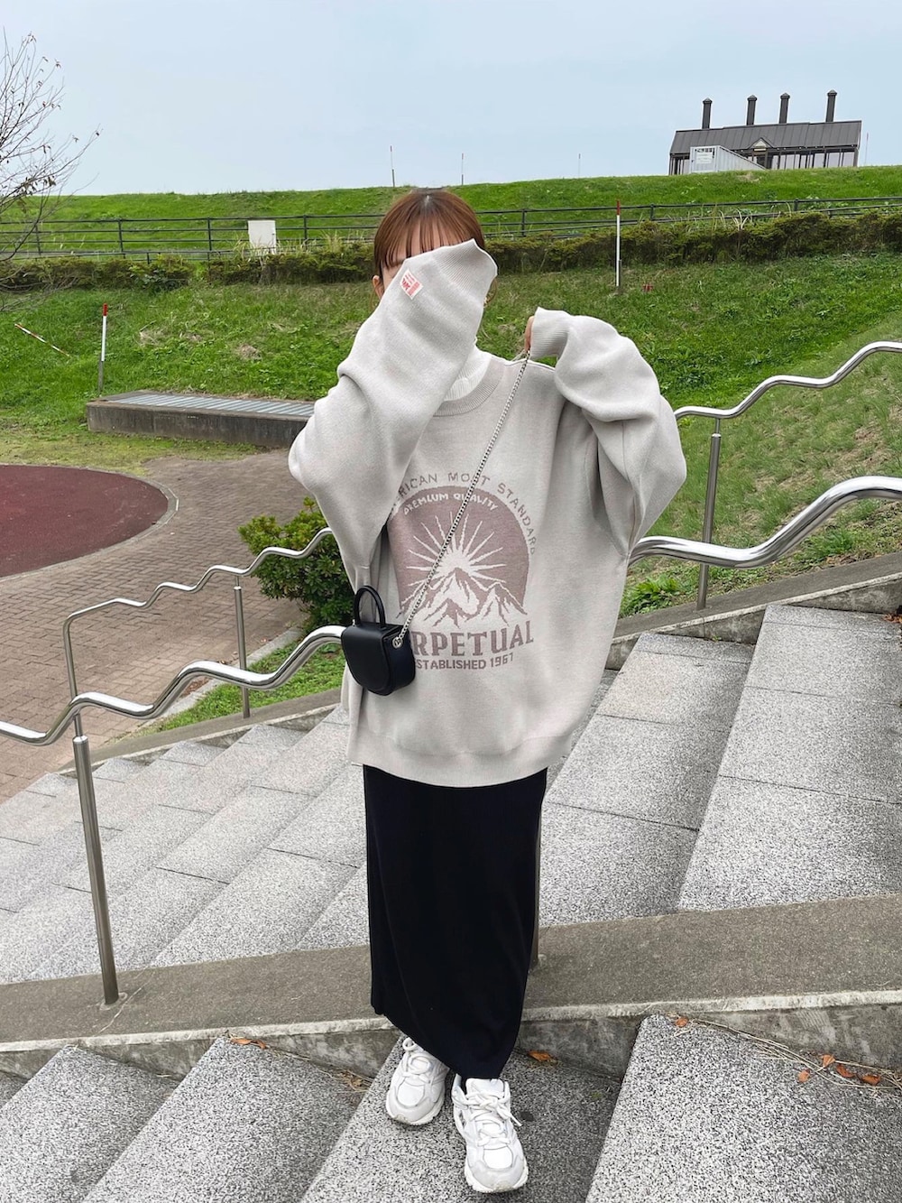 ベージュ系のニット/セーター、ホワイト系のニット/セーター、ブラック系のショルダーバッグを着用したレディースの冬コーディネートの5枚目の写真