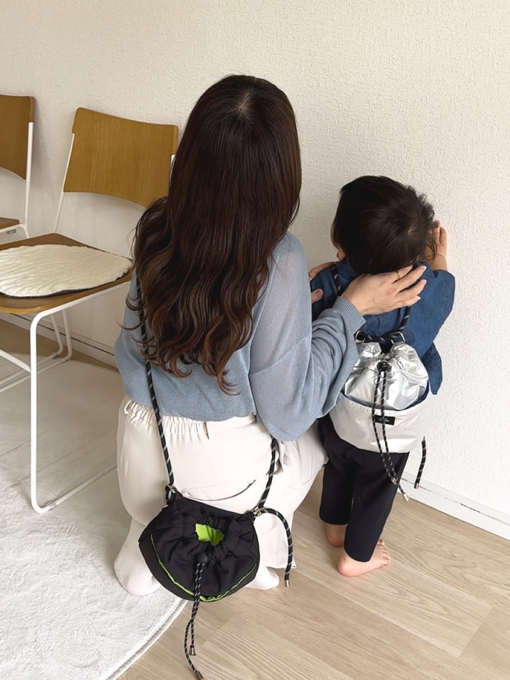 ブルー系のカーディガン/ボレロ、ホワイト系のスラックス、ブラック系のトートバッグを着用したレディースの秋コーディネートの4枚目の写真