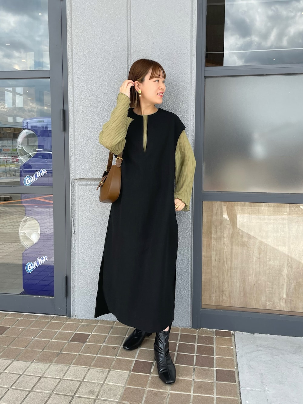 ブラック系のワンピース、グリーン系のシャツ/ブラウス、ブラウン系のバッグを着用したレディースの秋コーディネートの2枚目の写真