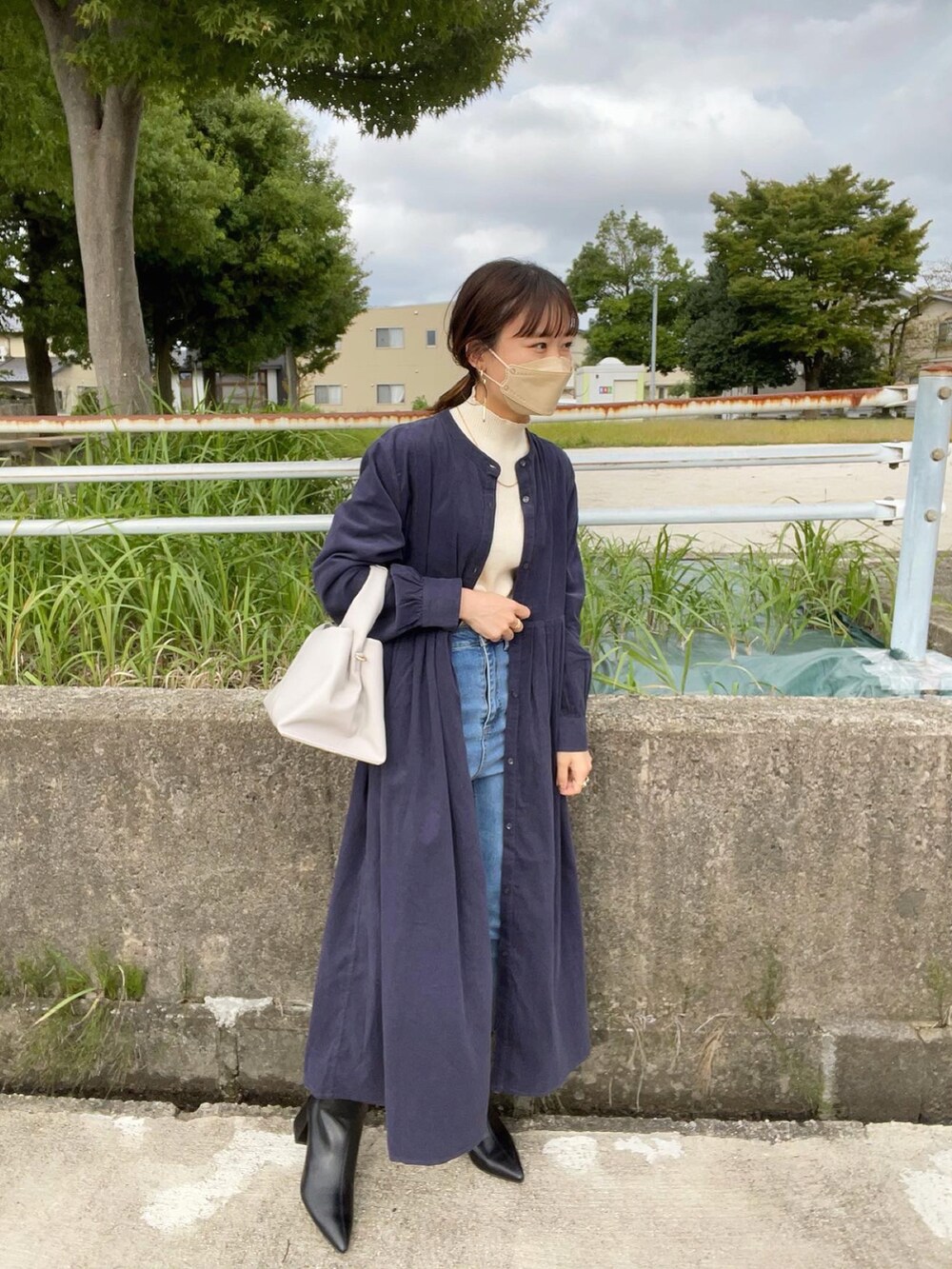 ブルー系のワンピース、ブラック系のブーツ、ホワイト系のニット/セーターを着用したレディースの秋コーディネートの3枚目の写真