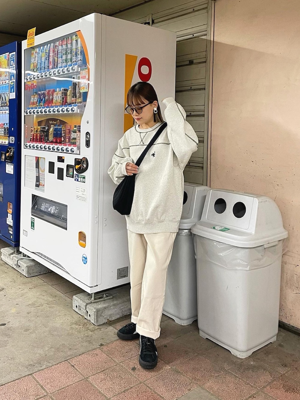 ベージュ系のスウェット、ベージュ系のデニムパンツ、ブラック系のショルダーバッグを着用したレディースの秋コーディネートの2枚目の写真
